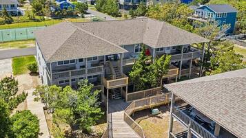 A multi-story residential building with a central courtyard, balconies, and a wooden deck.