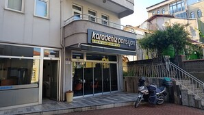 A building with a sign for 'Karodeniz Pansiyon' and a motorcycle parked outside. - Karadeniz Pansiyon (Amasra)