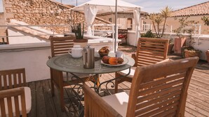 A wooden deck with a round table, chairs, and a white umbrella. - Stylish 2 bedroom apart. with breathtaking private Rooftop, garage (Nîmes)
