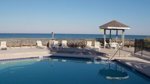 A pool area with lounge chairs and a gazebo overlooking the ocean. - SEACLUSION OFFERS GULF VIEWS & STEPS TO BEACH! 2 COMMUNITY POOLS! (Port Saint Joe)