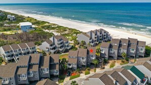 A coastal residential area with multi-story buildings, a beach, and a clear view of the ocean. - SEACLUSION OFFERS GULF VIEWS & STEPS TO BEACH! 2 COMMUNITY POOLS! (Port Saint Joe)