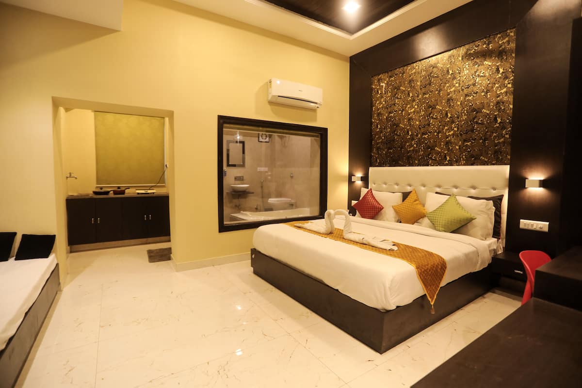 Una habitación de hotel moderna con una cama grande, un armario empotrado, un espejo amplio y un aire acondicionado de pared.