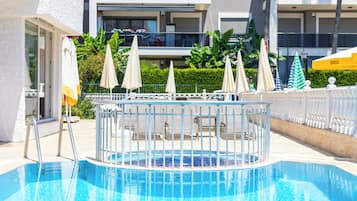 Piscine extérieure en saison, parasols, chaises longues