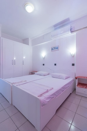 Relax in a cozy space with a double bed, wardrobe, and air conditioning for a comfortable stay.