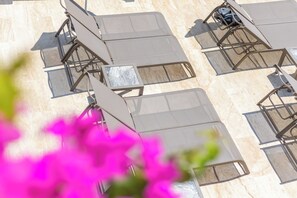 Una piscina al aire libre de temporada, sombrillas