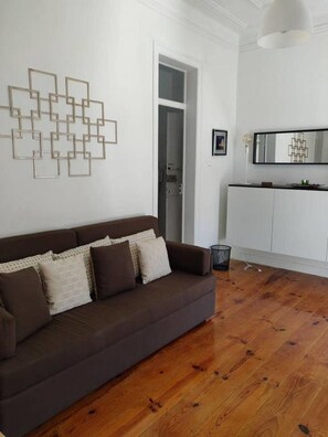 Relax in this stylish living room with a sofa, geometric art, and a cabinet with a mirror.