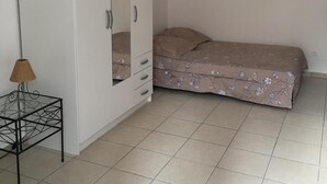 A bedroom with a bed, a wardrobe, and a small table with a lamp. - Studio in historic district of Corte (Corte)