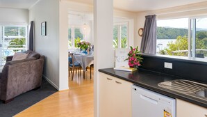 Une cuisine moderne avec un plan de travail noir et une vue sur un lac.
