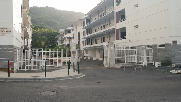 A gated residential complex with multiple floors and balconies, surrounded by greenery. - Studio any comfort. (Bas de la Rivière)