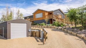 Une maison moderne à deux étages, dotée d’un espace extérieur couvert et d’un garage.