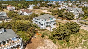 Un quartier résidentiel situé sur la côte, où les maisons se distinguent par leurs balcons imposants et offrent une vue sur le littoral.