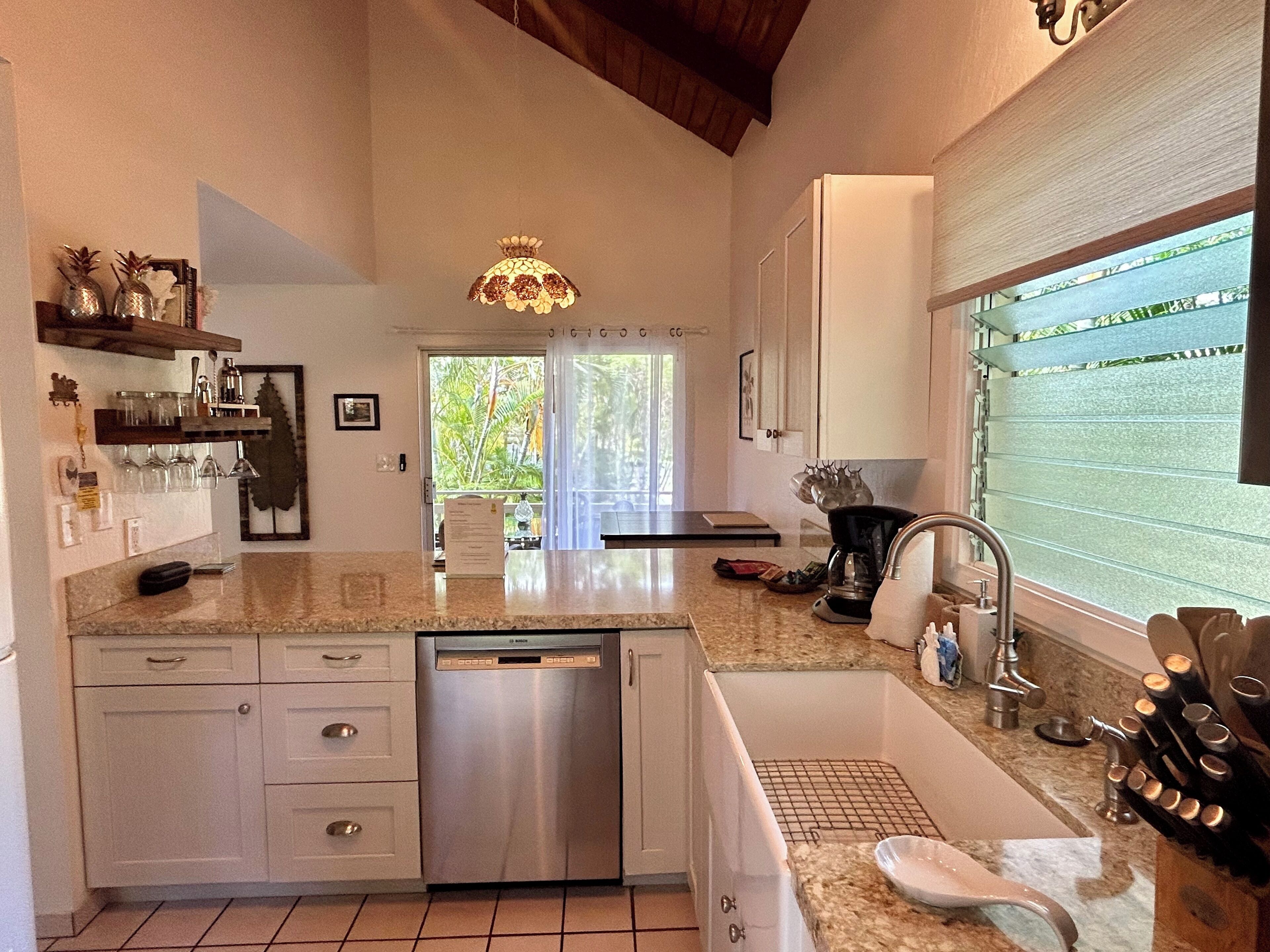A modern kitchen with a dishwasher, sink, and granite countertop.