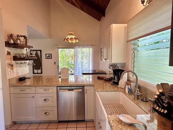 A modern kitchen with a dishwasher, sink, and granite countertop.