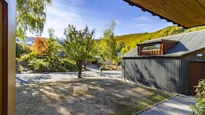 Un immobile residenziale con patio coperto, giardino recintato e vista su un paesaggio collinare.