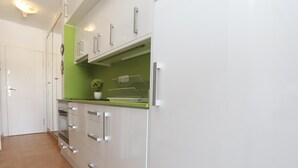 Une cuisine moderne avec des armoires blanches, un plan de travail vert et un four encastré.