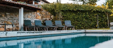 Piscine extérieure en saison, chaises longues