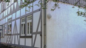 Edificio de entramado de madera con fachada blanca y ventana visible.