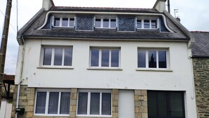 Ein zweistöckiges Haus mit Garage, Steinfundament und zahlreichen Fenstern.