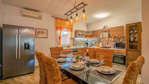Une cuisine moderne avec un coin repas aménagé pour accueillir six personnes.