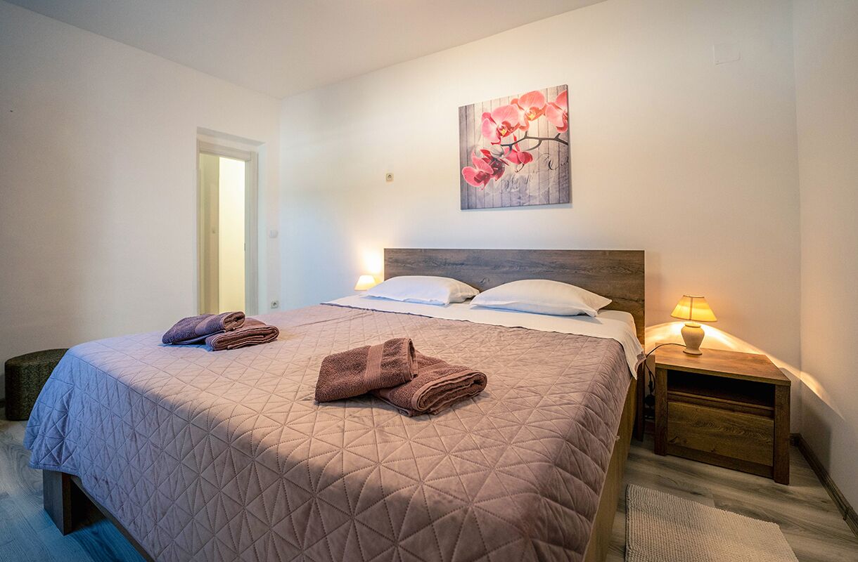 Una camera da letto con un letto, due comodini, una mensola e un'opera d'arte appesa al muro.