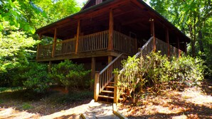 A wooden cabin with a balcony and a staircase leading to an upper level. - ❤ VERY ROMANTIC CABIN ❤ Near Cades Cove, WIFI, Hot Tub, Jacuzzi, Sauna (Townsend)