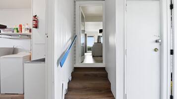 A hallway with a wooden staircase leading to a room with a view.