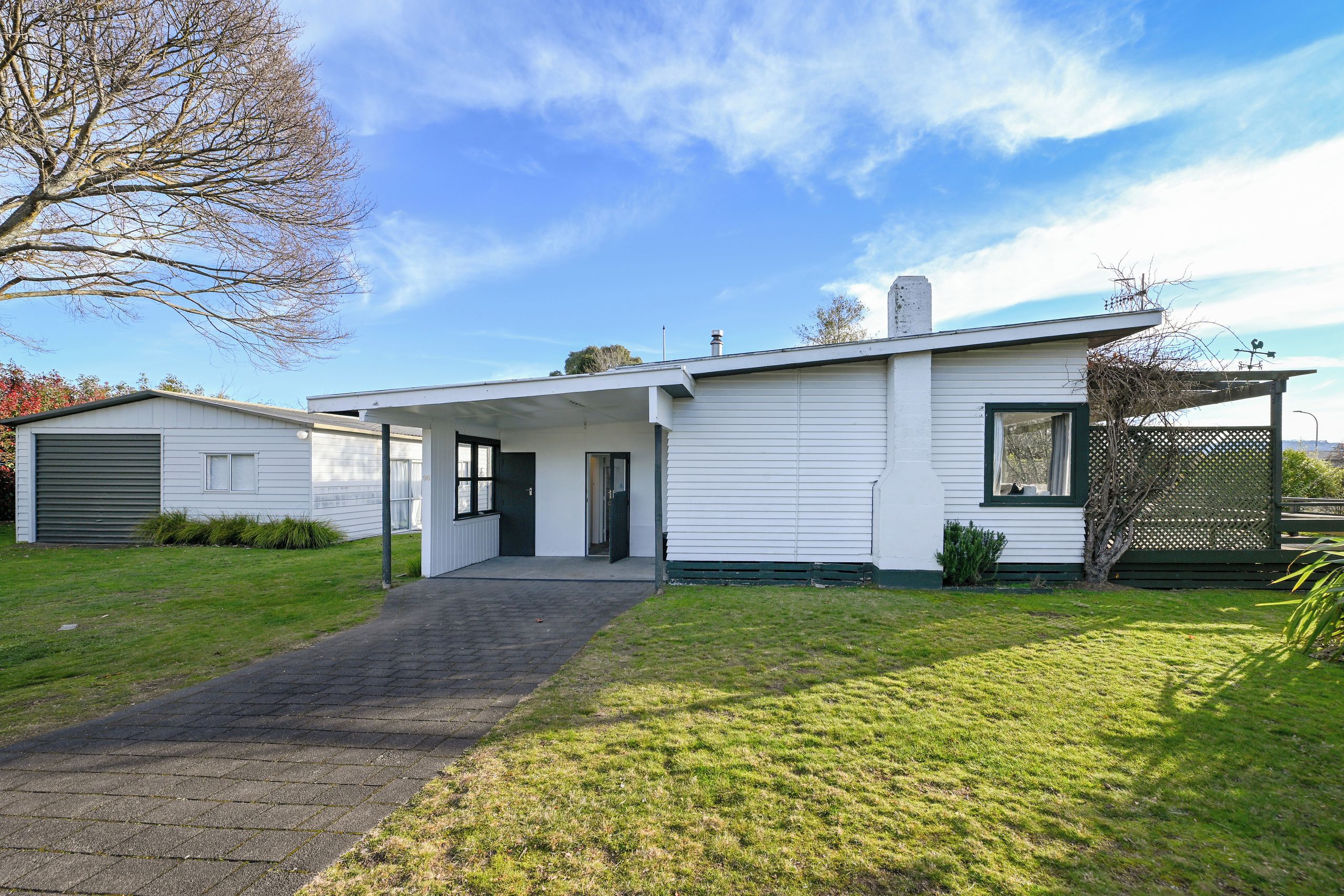 A single-story house with a covered porch, a garage, and a well-maintained lawn.
