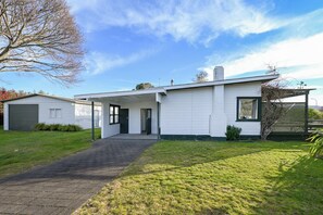 A single-story house with a covered porch, a garage, and a well-maintained lawn.
