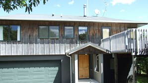 A two-story house with a garage, a front porch, and a satellite dish. - Aqua Views - Kuratau Holiday Home (Kuratau)