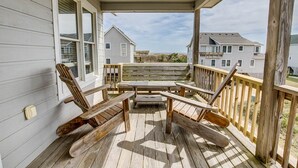 A wooden deck with a table and chairs, overlooking a residential area. - Near The Edge | 95 ft from the beach | Community Pool | Duck (Duck)