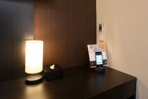 Et natbord med lampe, toiletpapir og en Wi-Fi opladestation.
