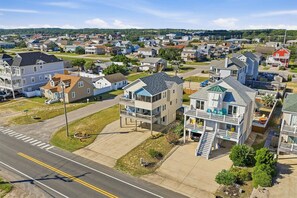 A residential area with houses, a road, and a clear sky. - Spur of the Moment | 293 ft from the beach | Private Pool, Hot Tub | Kill Devil Hills (Kill Devil Hills)