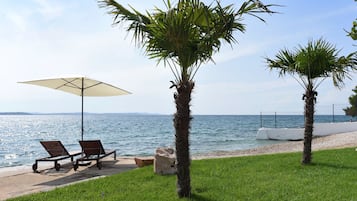 Playa privada, playa de arena blanca, camastros y sombrillas