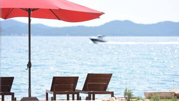 Playa privada, playa de arena blanca, camastros y sombrillas