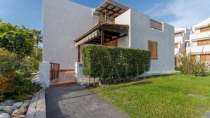 Un bâtiment moderne à deux étages, doté d’un chemin pavé menant à l’entrée, entouré de verdure et d’une pelouse bien entretenue.