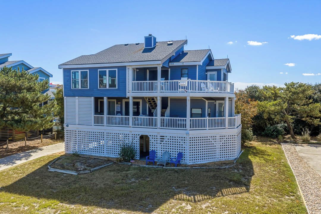 A two-story house with a balcony, a covered porch, and a small front yard.