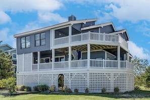 A two-story house with a balcony, a covered porch, and a fenced yard.