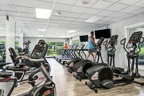 A gym with treadmills, elliptical machines, and stationary bikes.