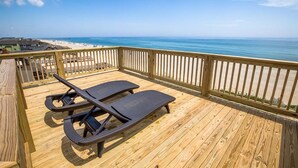 A wooden deck with two lounge chairs facing a beach. - The Beach House | Oceanfront | Dog Friendly, Private Pool, Hot Tub | Nags Head (Nags Head)