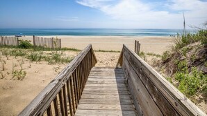 A wooden boardwalk leading to a sandy beach with a clear view of the ocean. - The Beach House | Oceanfront | Dog Friendly, Private Pool, Hot Tub | Nags Head (Nags Head)