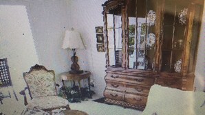 Ein Zimmer mit einem Bett, einem kleinen Tisch und einem Fenster.