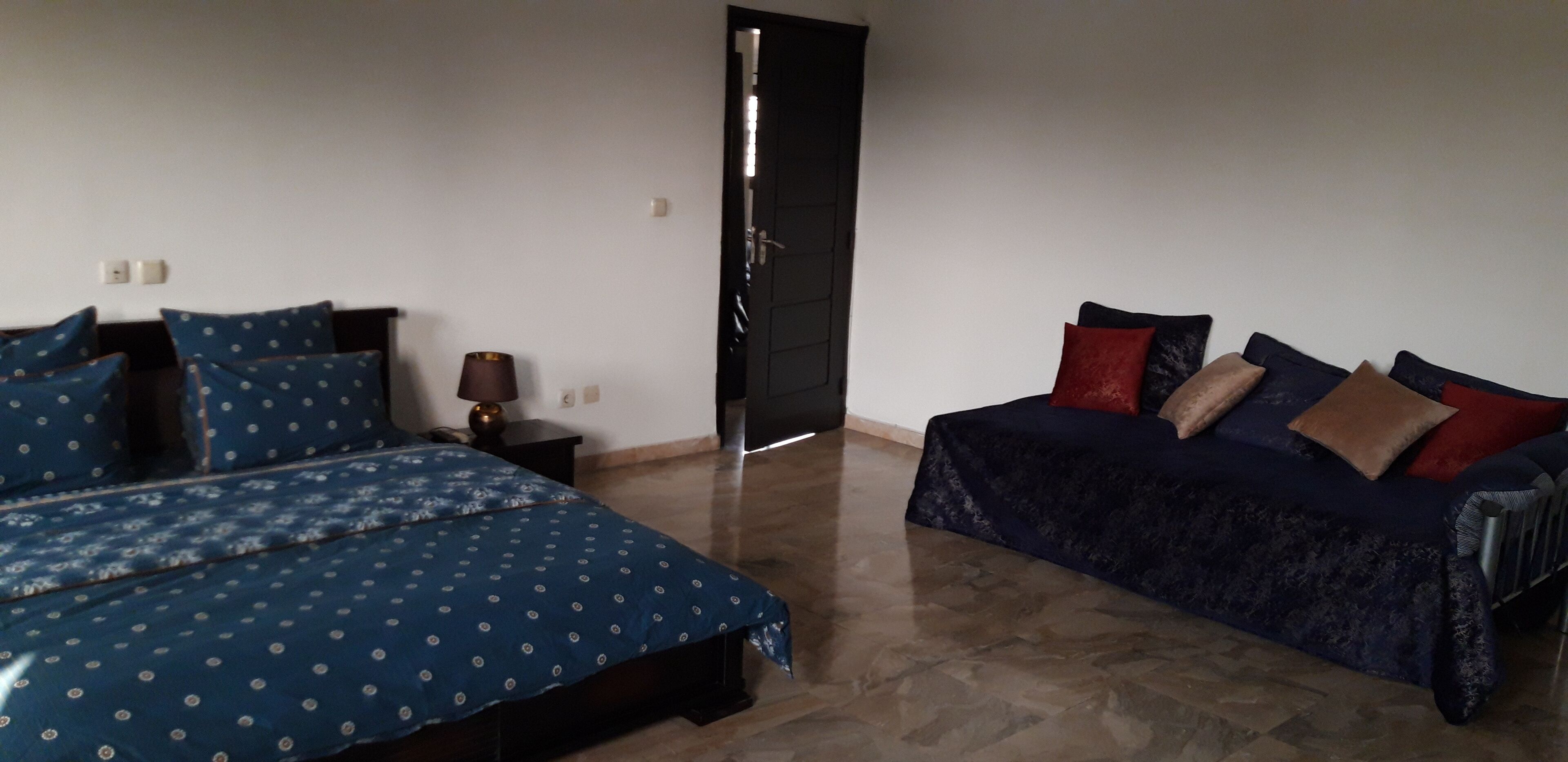 Un dormitorio con una cama a la izquierda y un sofá a la derecha.