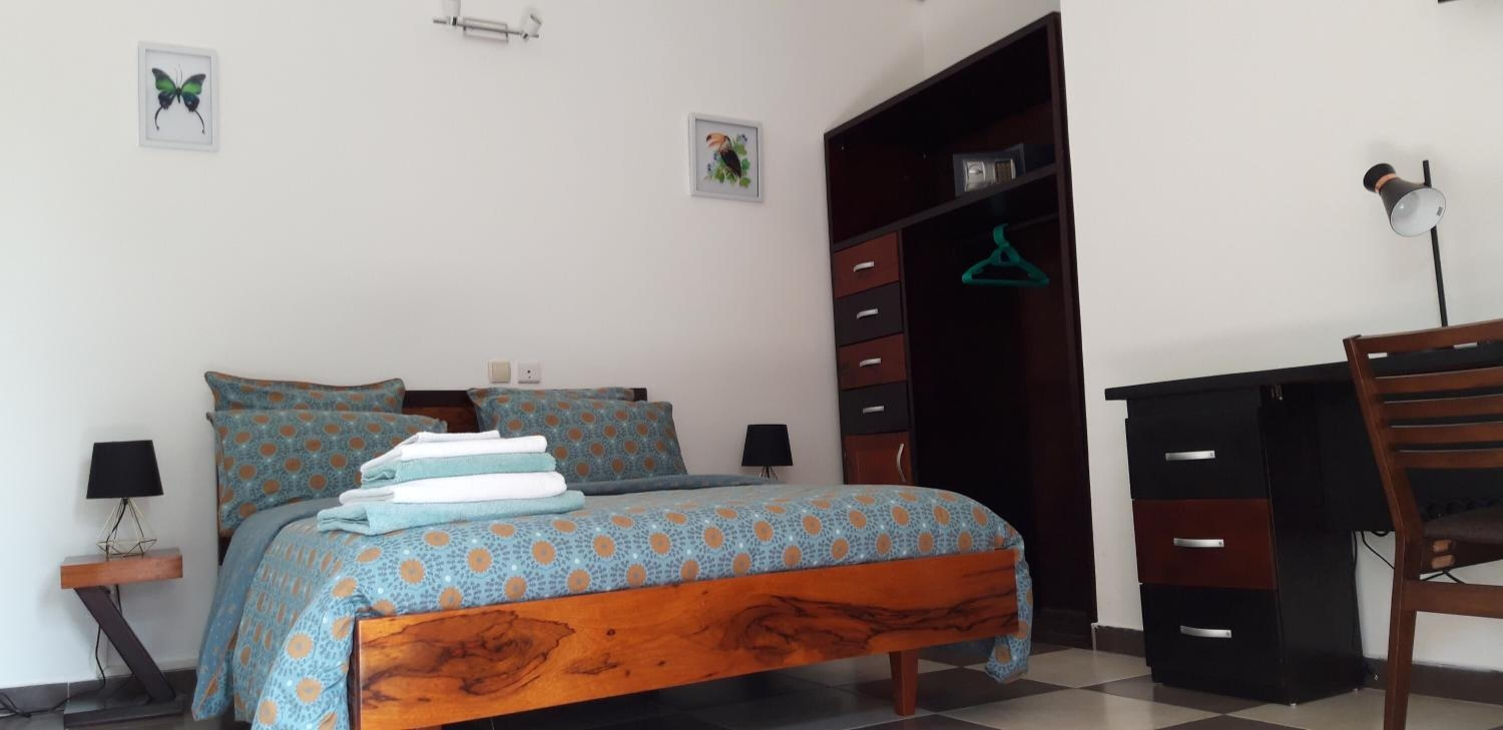 Una camera da letto con un letto, una scrivania, una sedia e un armadio.