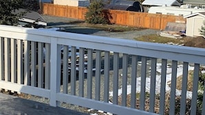 A snowy landscape with a wooden fence, a clear sky, and distant mountains.