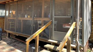 A wooden cabin with a large screened porch, a wooden staircase, and a metal mesh door. - Cabin in The Pines.. **Available 240v Tesla and EV charging.  (Heber-Overgaard)