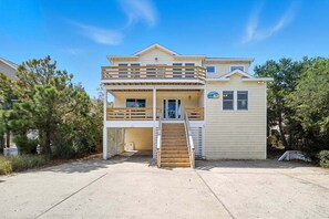 A two-story house with a balcony and a small porch. - Tropical Dream | 620 ft from the beach | Dog Friendly, Private Pool, Hot Tub | Corolla (Corolla)