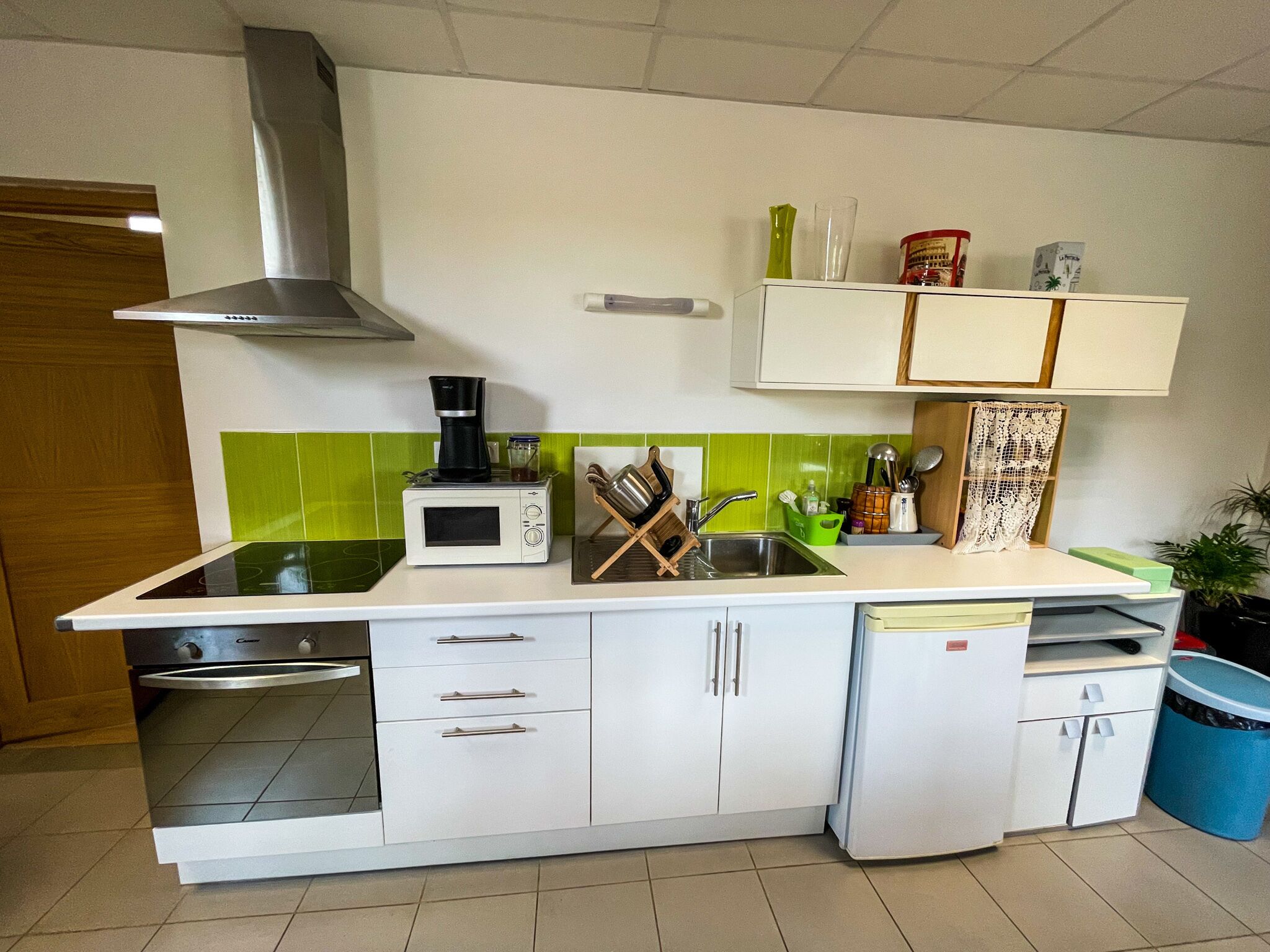 Een koffiezetapparaat/waterkoker, een koelkast, een oven, een kookplaat