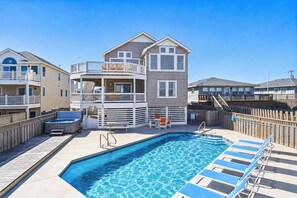 A swimming pool area with a wooden deck, lounge chairs, and a hot tub. - Krosnest | Oceanfront | Private Pool, Hot Tub | Nags Head (Nags Head)