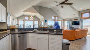 A spacious kitchen with a dishwasher, a large island, and a view of the sea. - Krosnest | Oceanfront | Private Pool, Hot Tub | Nags Head (Nags Head)