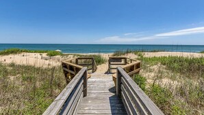A wooden boardwalk leading to a beach with sand dunes and sparse vegetation. - Krosnest | Oceanfront | Private Pool, Hot Tub | Nags Head (Nags Head)